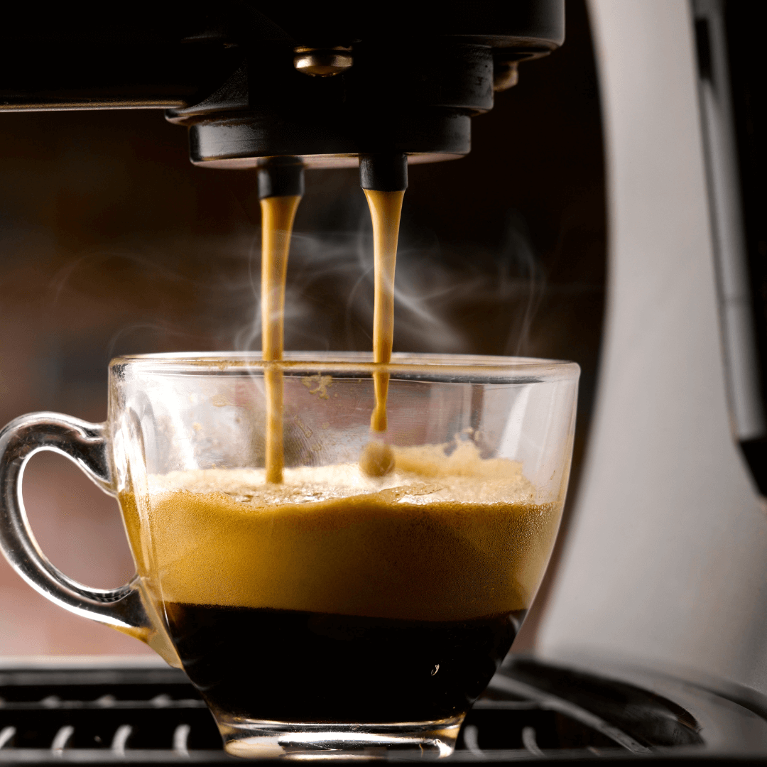 A sleek coffee machine deftly pulls a double espresso shot. The rich, aromatic stream of coffee flows into a waiting cup, promising a bold and invigorating flavour