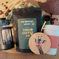 the ultimate coffee gift set with a bag of coffee, a cafetiere, a reuseable coffee mug, a giraffe wooden coaster and a reusable hessian gift sack