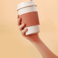 a person holding a reusable coffee mug
